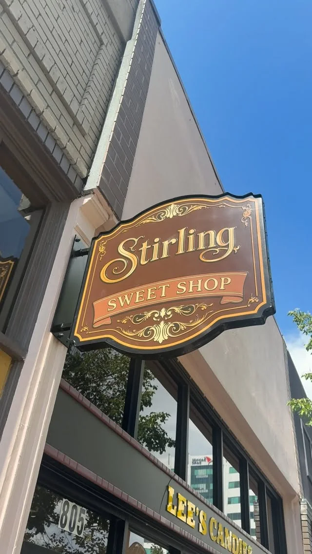 The ornate Stirling Sweet Shop hanging sign above 805 W Bannock Street